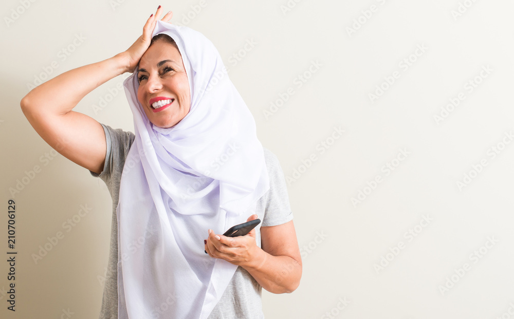 Arabian woman using smartphone stressed with hand on head, shocked with shame and surprise face, angry and frustrated. Fear and upset for mistake. Arabian woman using smartphone stressed with hand on head, shocked with shame and surprise face, angry and frustrated. Fear and upset for mistake.