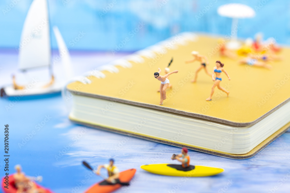 Miniature people : Travelers have activities on the beach and swimming on blue ocean. Image use for sport, vacation ,travel concept.