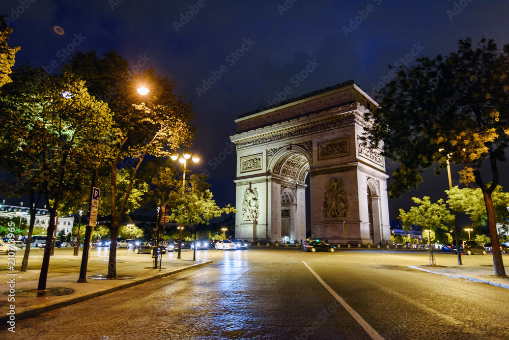 Paris, France - August 9, 2017. Night view on Triumphal Arch at the center of Place Charles de Gaulle, on the top of Champs Elysees. Famous historical monument in Paris, popular touristic landmark.