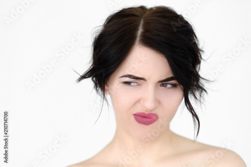 emotion face. discontent dissatisfied envious woman looking sideways and thinking. young beautiful brunette girl portrait on white background.