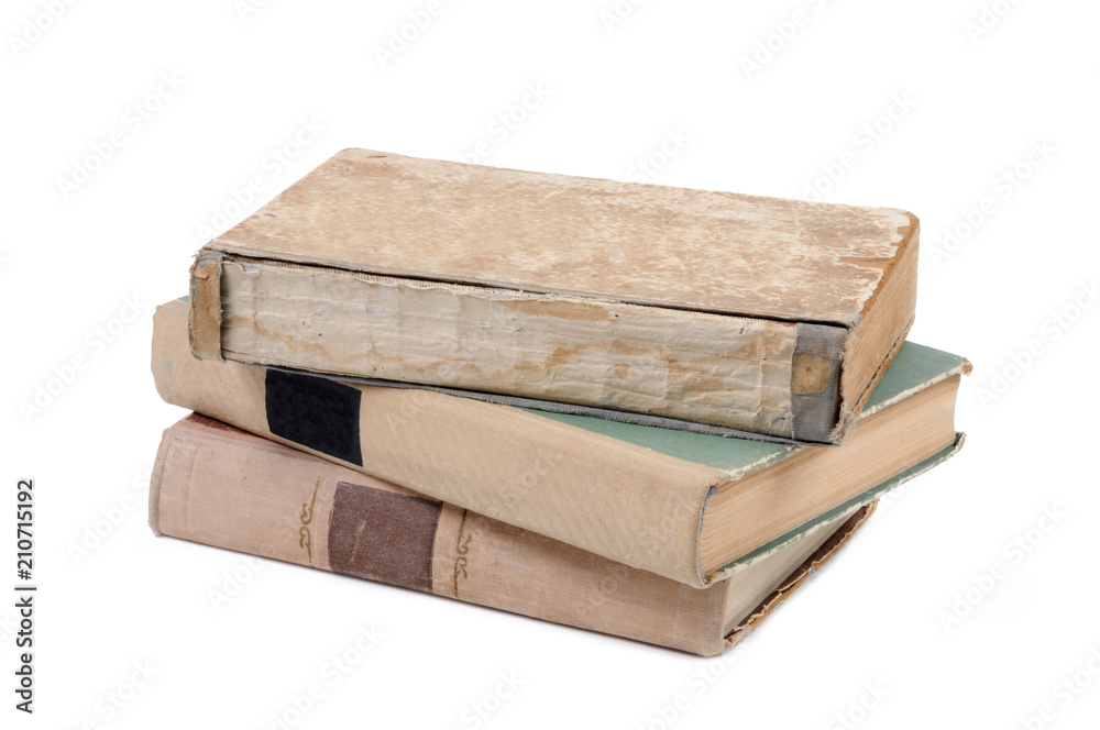 Three old books in a pile isolated on white background. Front view. Three old books in a pile isolated on white background. Front view.