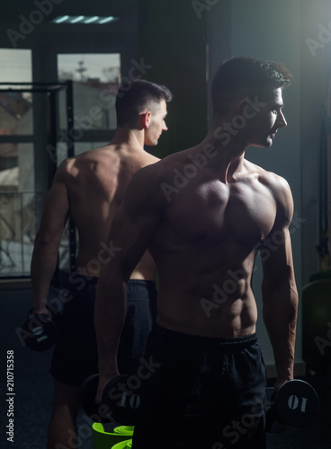 Man with torso, muscular macho and his reflexion in mirror background. Sport and gym concept. Sportsman, athlete with muscles looks attractive. Man with nude torso in gym enjoy his sporty lifestyle