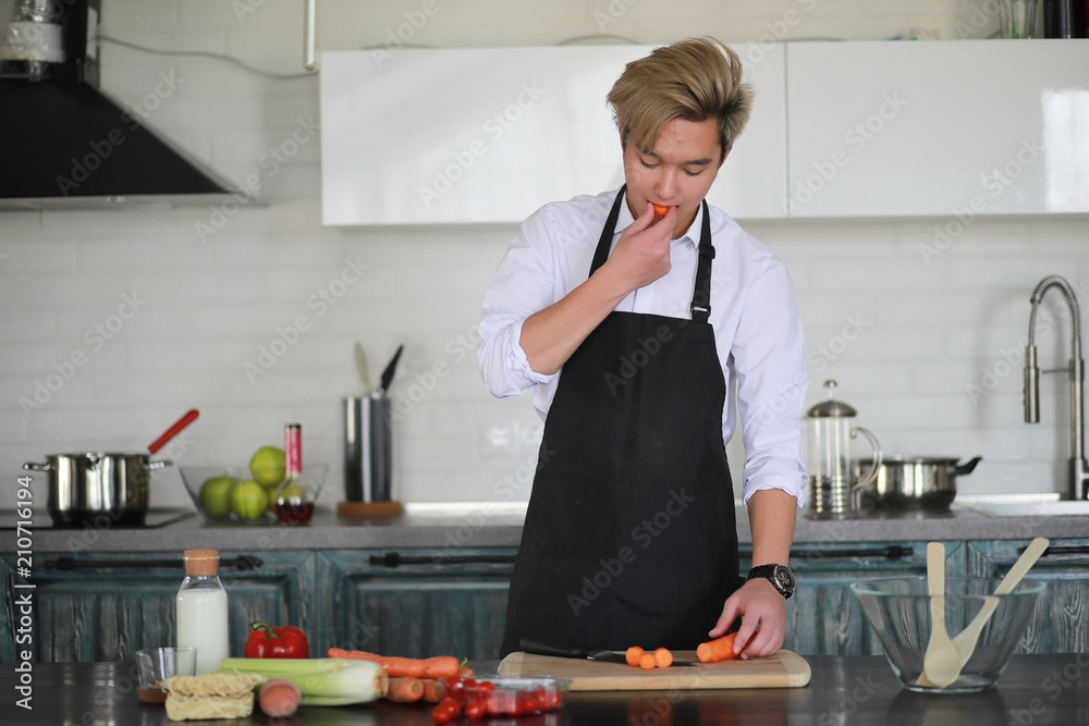 Asian cook in the kitchen prepares food in a cook suit Asian cook in the kitchen prepares food in a cook suit