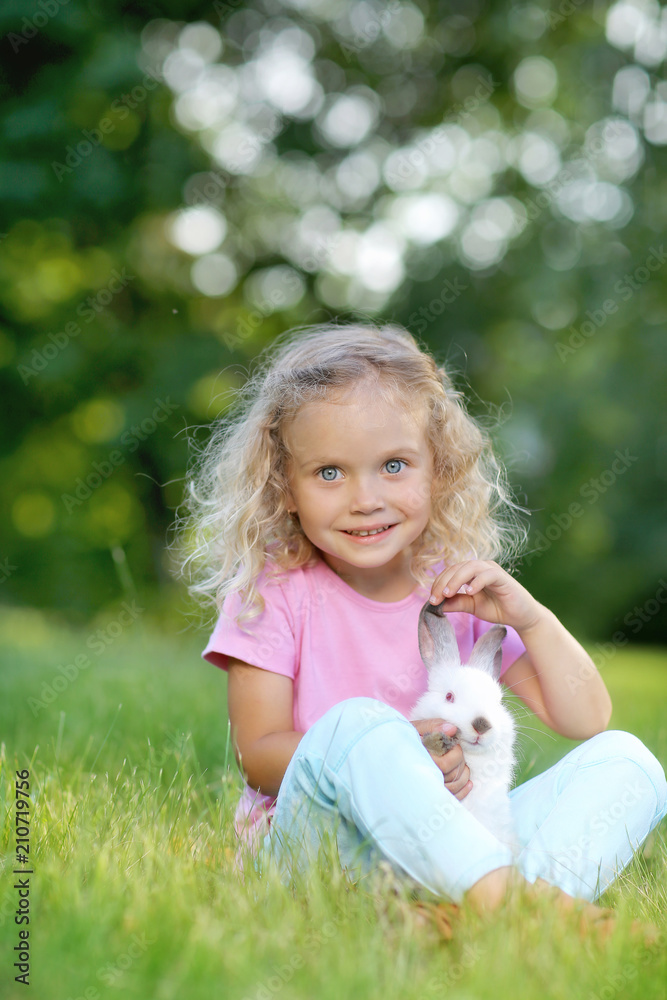 Girl with a cute little rabbit, outdoor, summer day Girl with a cute little rabbit, outdoor, summer day