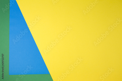 Color papers composition background with yellow, green and blue tones