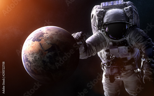 Earth on a blurred background with a giant astronaut. Elements of the image are furnished by NASA