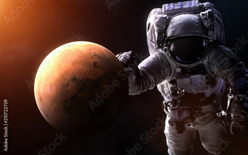 Fototapeta Naklejka Na Ścianę i Meble -  Mars on a blurred background with a giant astronaut. Elements of the image are furnished by NASA