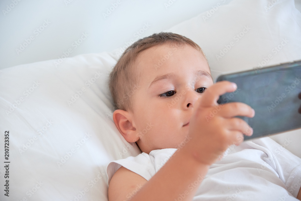 baby boy before going to bed and watching cartoons in the smartphone baby boy before going to bed and watching cartoons in the smartphone