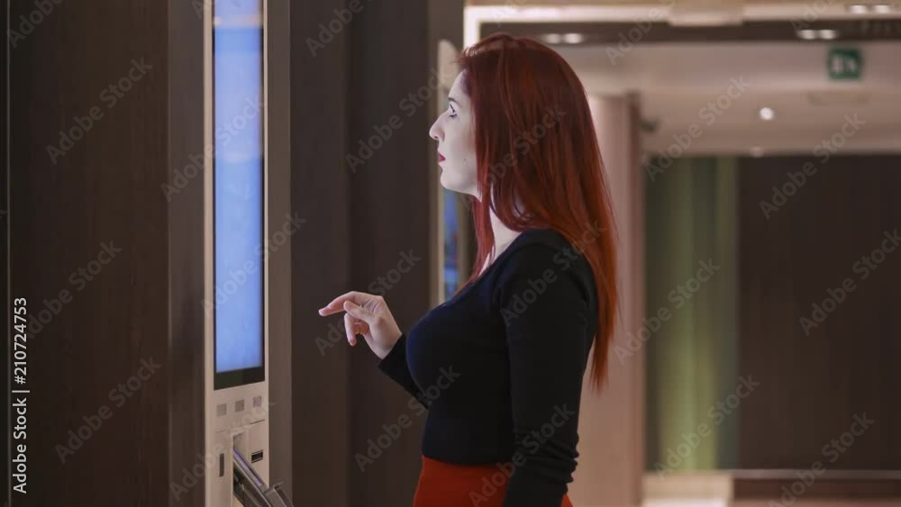 Elegant beautiful woman choosing snacks from a digital vendig machine Elegant beautiful woman choosing snacks from a digital vendig machine