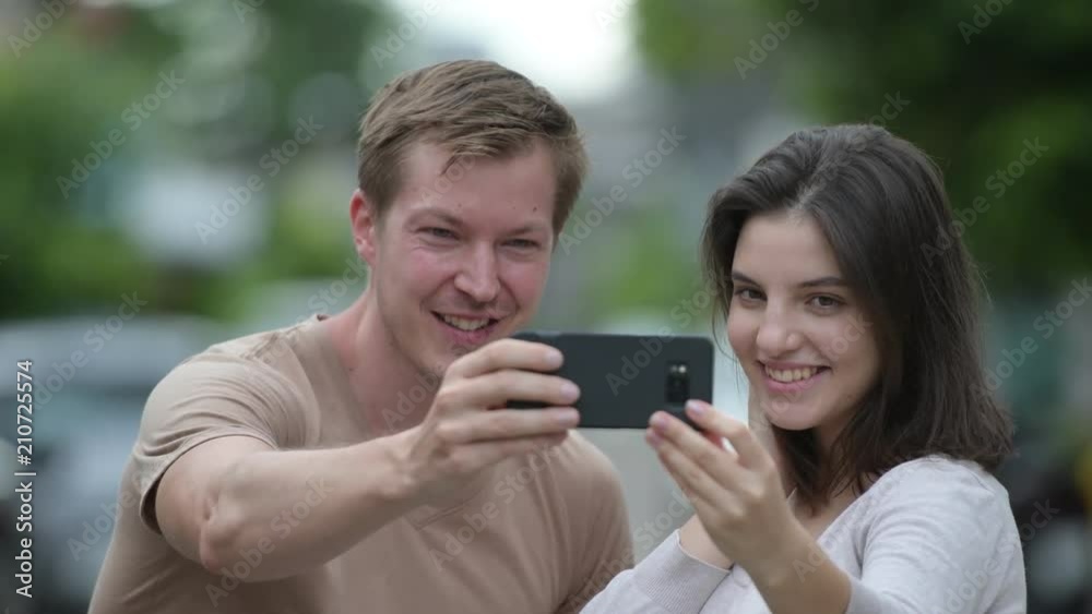 Young happy couple taking selfie together in the streets outdoors Young happy couple taking selfie together in the streets outdoors