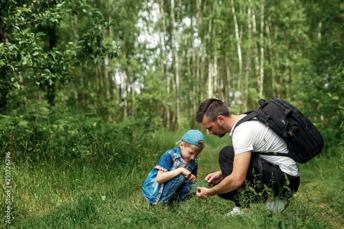 Принти на полотні A man with a backpack, a father and his son on a hike, walking during walks in the woods