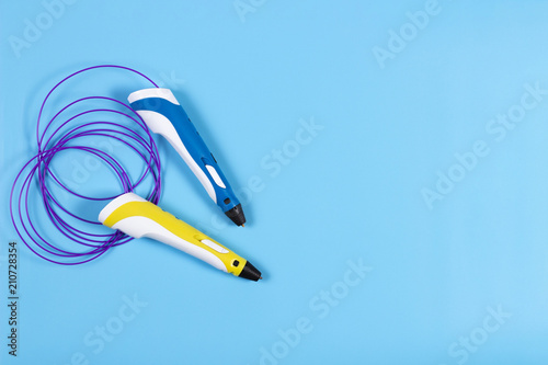 3d pens with colourful plastic filament on blue background