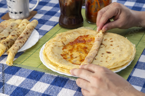 Female hands filling home crepes or balkan pancakes rolls photo