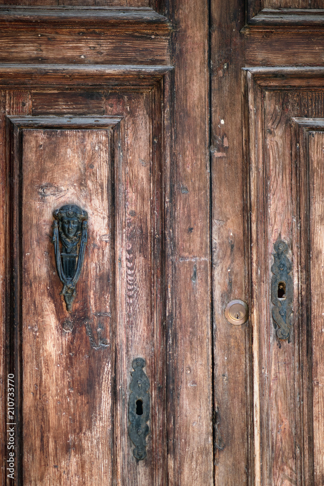 Antique wooden front door with ornate knocker. Antique wooden front door with ornate knocker.