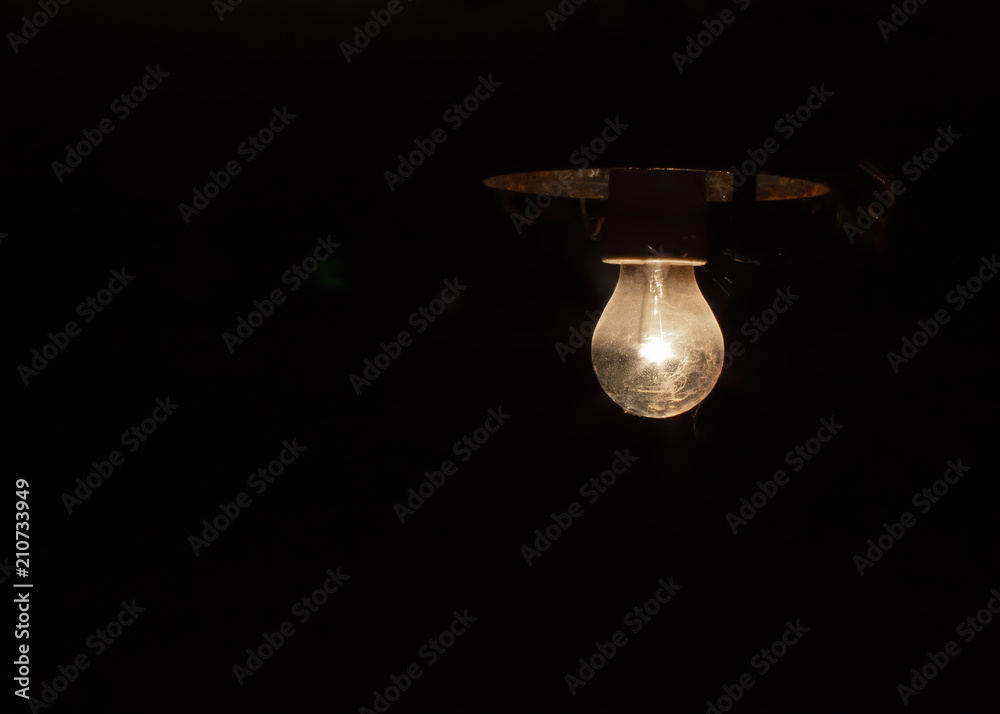 Light of old electric light bulb lighting in darkness Light of old electric light bulb lighting in darkness