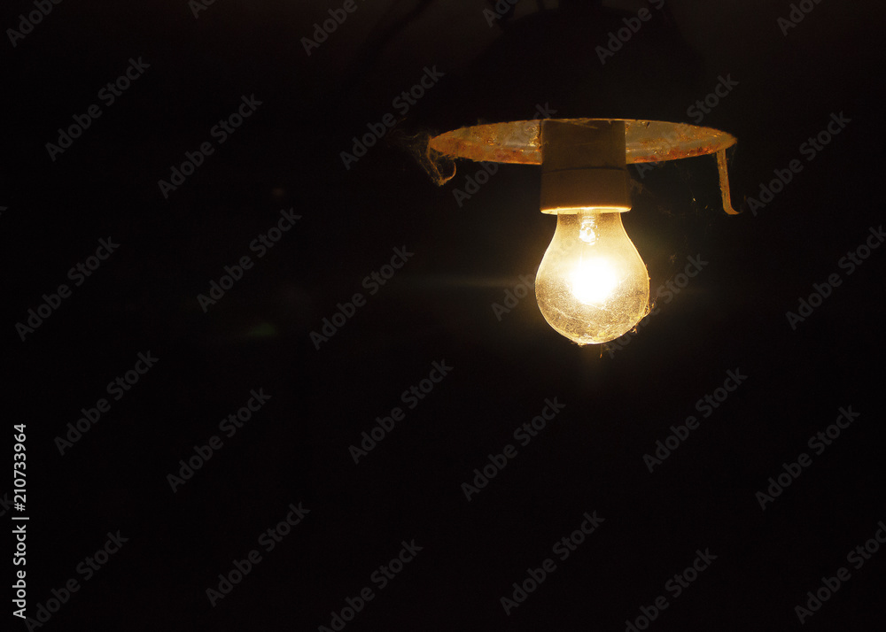 Light of old electric light bulb lighting in darkness