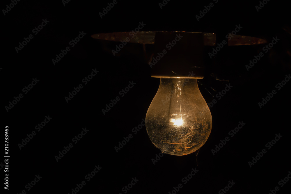 Light of old electric light bulb lighting in darkness Light of old electric light bulb lighting in darkness