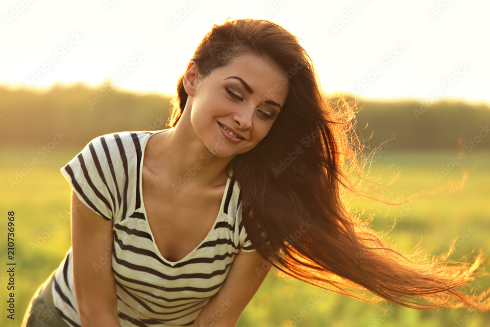 Beautiful smiling young woman looking happy with long amazing bright hair on nature bright sunset summer background. Closeup portrait Beautiful smiling young woman looking happy with long amazing bright hair on nature bright sunset summer background. Closeup portrait