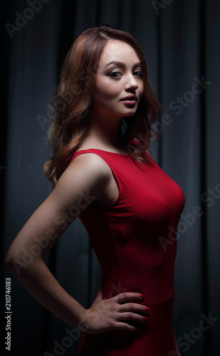 Girl in a red dress on a dark background