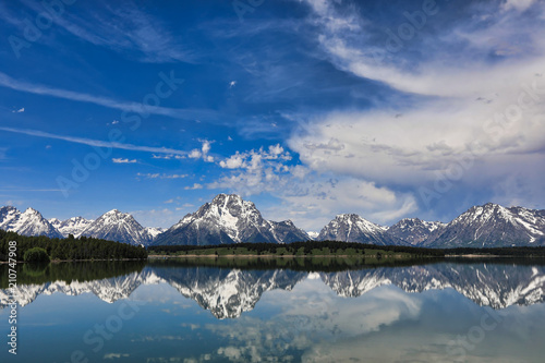The Grand Tetons of Wyoming are reflected perfectly in the still waters of Jackson Lake