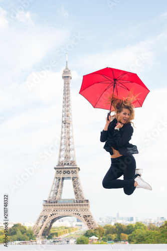 Happy woman travel in paris, france. Woman jump with fashion umbrella. Girl with beauty look at eiffel tower. Parisian isolated on white background. Travelling and wanderlust. Enjoy summer vacation © be free