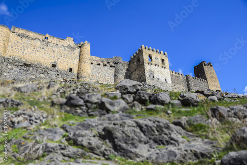 tilt shift landscape castle in the mountains stones mountains grass blue sky