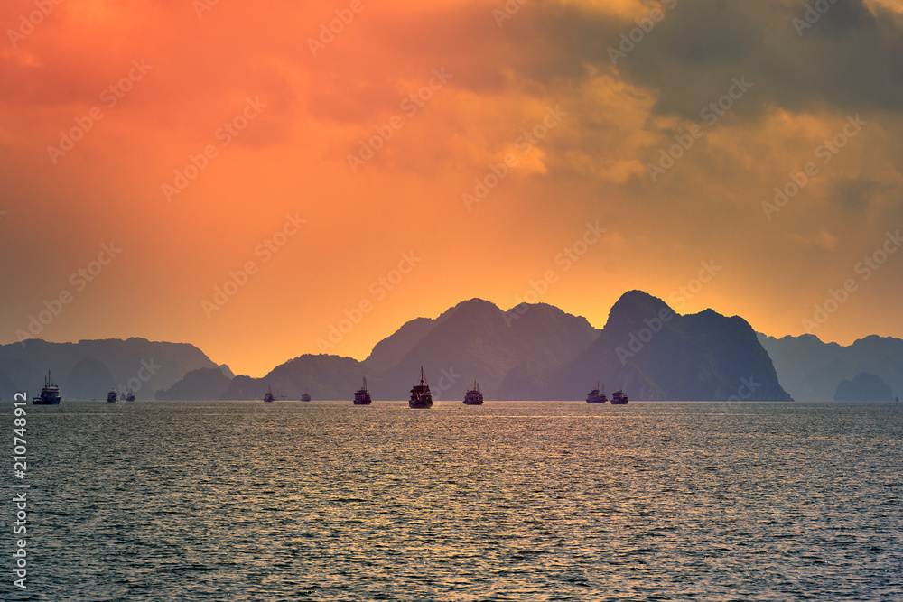 Tourist Junks in Halong Bay,Panoramic view of sunset in Halong Bay, Vietnam, Southeast Asia Tourist Junks in Halong Bay,Panoramic view of sunset in Halong Bay, Vietnam, Southeast Asia