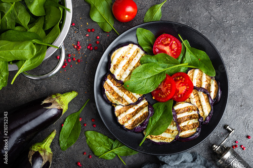 Grilled eggplant with fresh tomatoes and spinach leaves