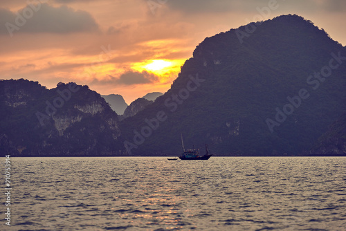 Halong bay boats  Vietnam Panoramic view of sunset in Halong Bay  Vietnam  Southeast Asia UNESCO World Heritage Site  Poor lighting conditions