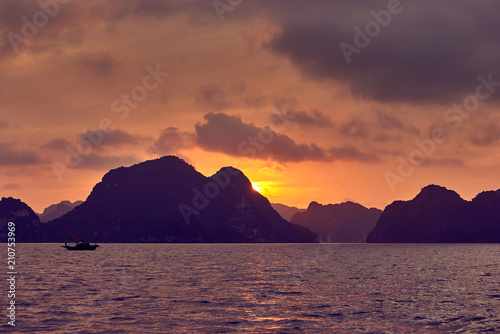 Halong bay boats  Vietnam Panoramic view of sunset in Halong Bay  Vietnam  Southeast Asia UNESCO World Heritage Site  Poor lighting conditions