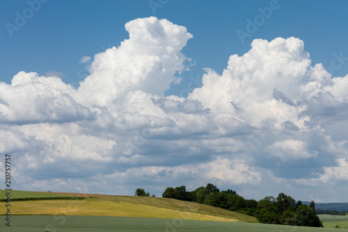 Gewitterbildende Cumulus-Wolken über frühsommerlichen Feldern