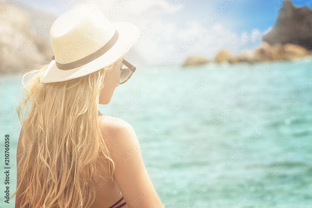 Fashion woman in summer hat relaxing on the beach.