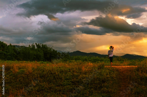 little kid playing paper airplane on mountain at sunset