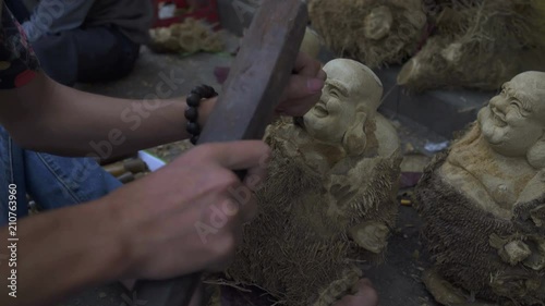 Making Buddha figurines from a tree with a chisel photo