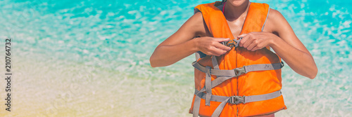 Watersport woman putting on orange life jacket for satefy on ocean activity. Panorama banner header crop. Sport lifestyle.