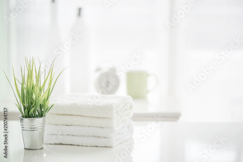 Towels on white table with copy space on blurred bathroom background