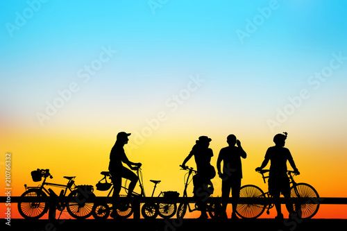 Silhouette group  bike relaxing on blurry sunrise background