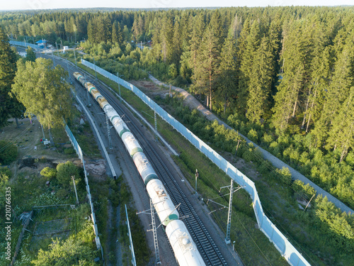 Aerial view on a freight train with tanks goes by suburban railway