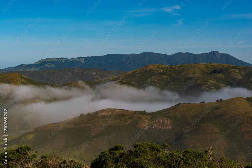 The fog rolls in to the valley between the mountains in San Francisco Ca.