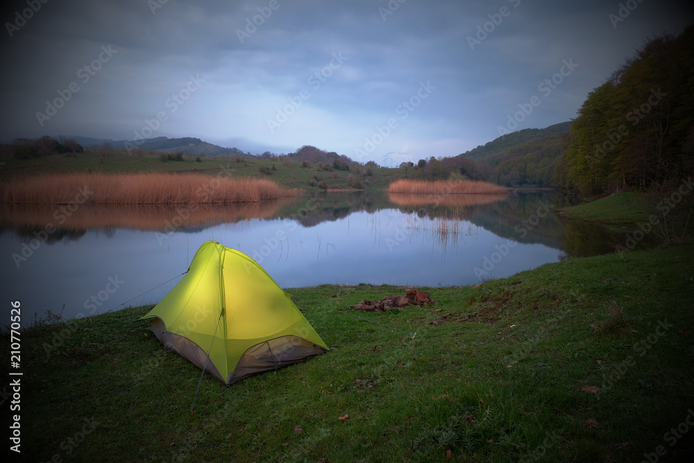 Obraz premium Illuminated Tent By Lake In Overcast Evening, Sicily