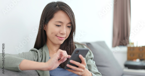 Housewife using smart phone at home