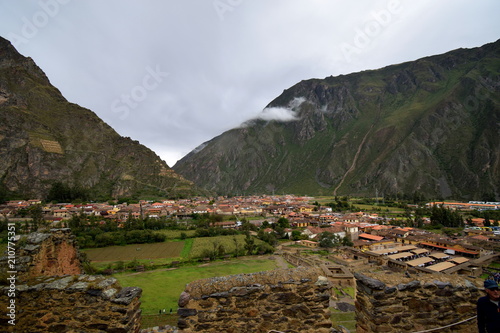 the valley town of Ollantaytambo visible from atop an incan ruin site in the sacred valley, Peru