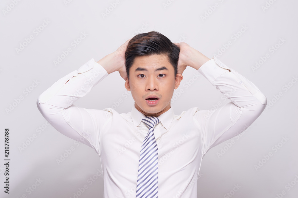 Shocked face of Asian man in white shirt on grey background. Shocked face of Asian man in white shirt on grey background.