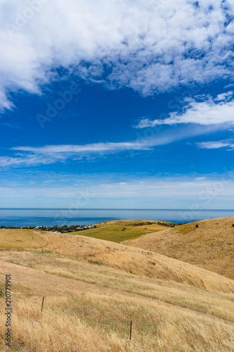 Countryside landscape with rolling hills and sea on sunny day