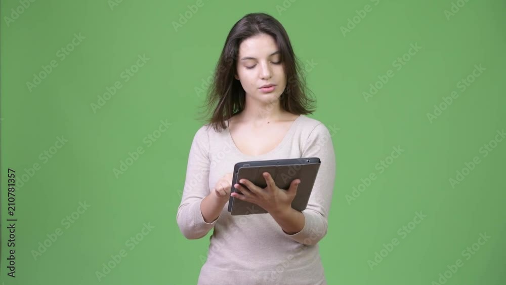Young happy beautiful woman thinking while using digital tablet Young happy beautiful woman thinking while using digital tablet