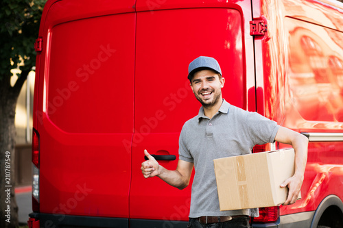  delivery man with cardbox in hands on the streets