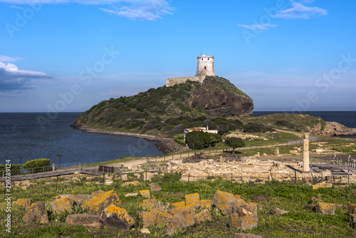 Ancient tower situated on a hill at the mediterranean sea with the ruins of Tharros in front  Sardinia  Italy