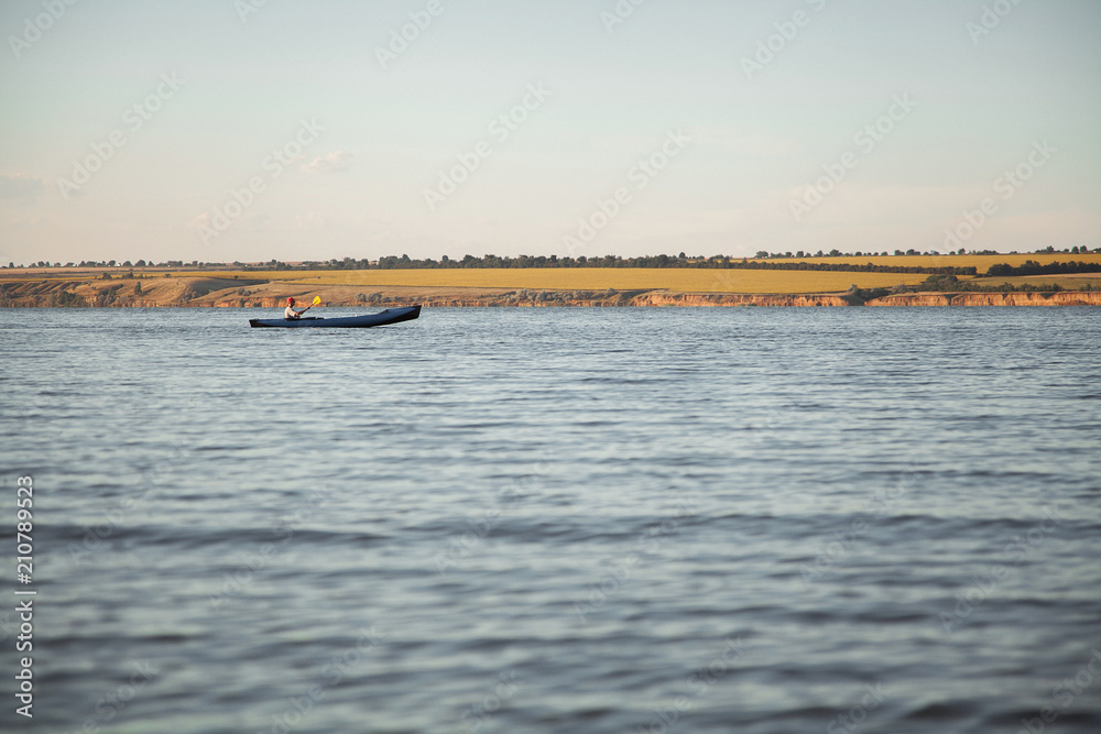 Beautiful scenery of the river bank, lake. Quiet evening. A small boat is floating on the water. Beautiful scenery of the river bank, lake. Quiet evening. A small boat is floating on the water.