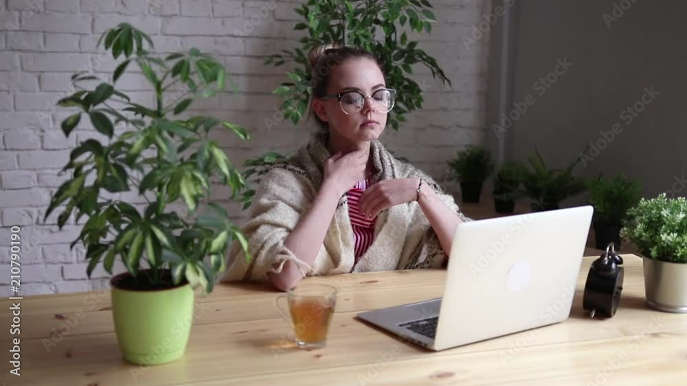 Portrait of a frustrated girl blowing her nose in a handkerchief while working with a laptop. The concept of an unhappy sick worker. Portrait of a frustrated girl blowing her nose in a handkerchief while working with a laptop. The concept of an unhappy sick worker.