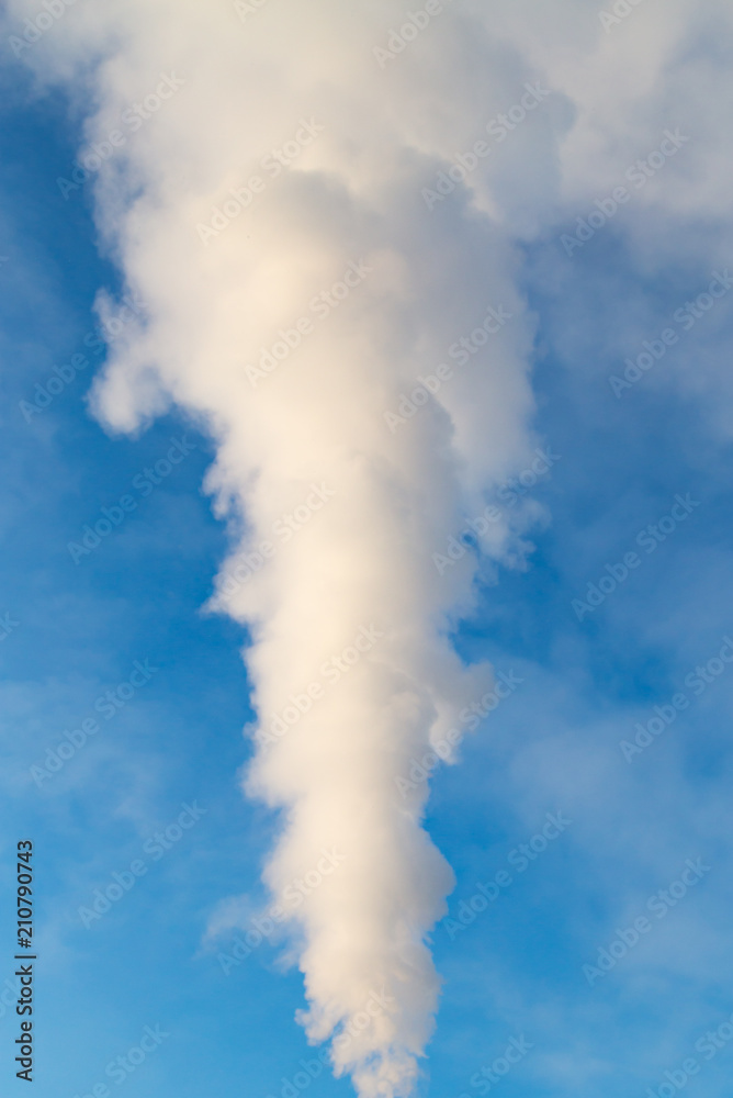 smoke from a pipe in the factory against a blue sky